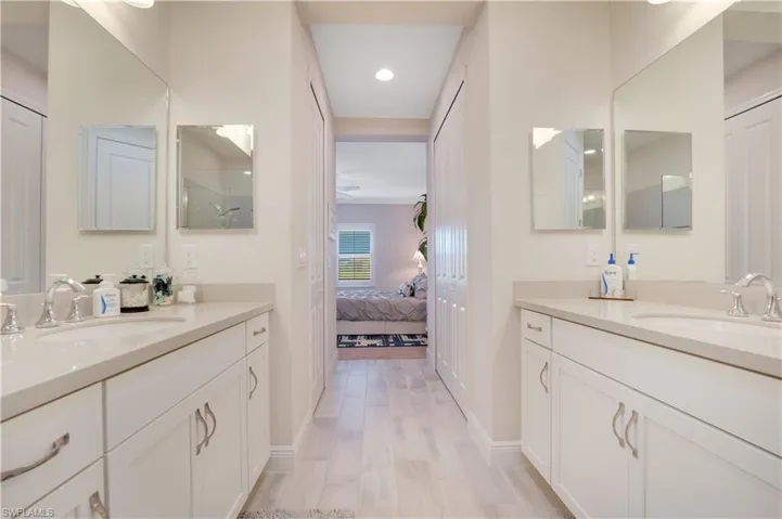Bathroom featuring a closet, vanity, and ensuite bath