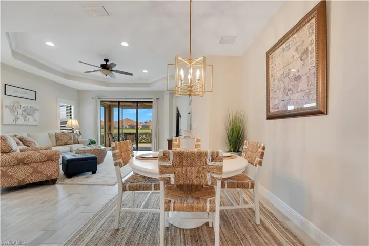 Dining area with recessed lighting, visible vents, baseboards, light wood-type flooring, and a tray ceiling