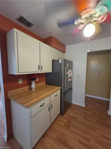 Kitchen featuring stove, light wood-type flooring, white cabinetry, and butcher block counters