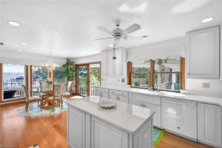 Kitchen featuring dishwasher, ceiling fan, recessed lighting, light wood-style floors, and white cabinetry