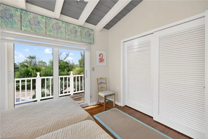 Bedroom featuring access to outside, dark wood finished floors, and a closet