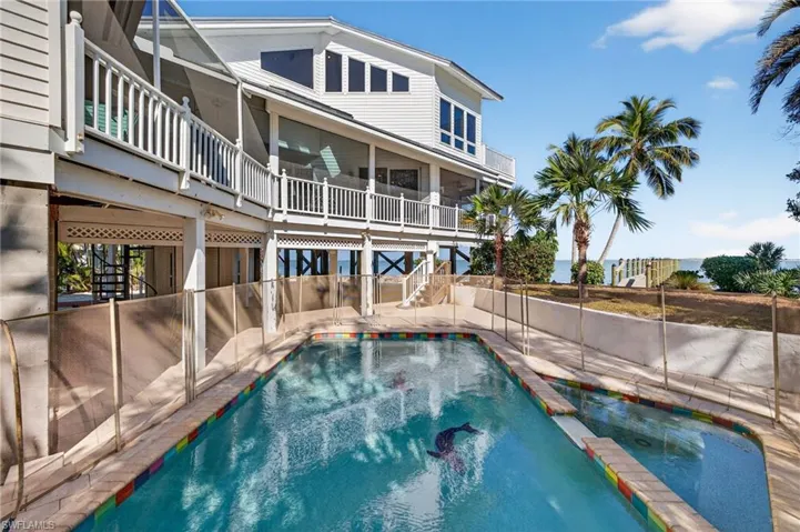 View of swimming pool featuring a pool with connected hot tub, a balcony, stairway, and a patio area