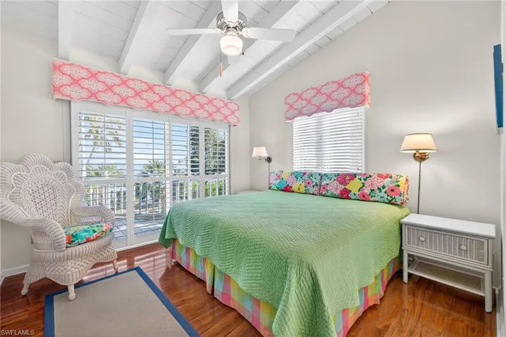 Bedroom featuring access to outside, dark wood-type flooring, a ceiling fan, and wooden ceiling