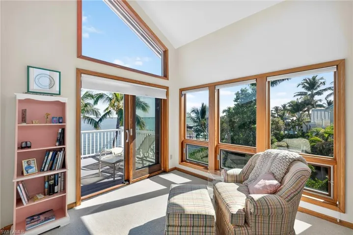 Sunroom featuring carpet and high vaulted ceiling