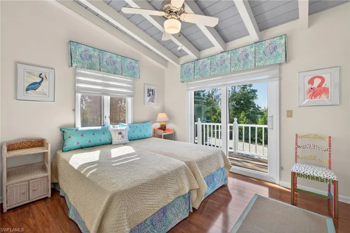 Bedroom with dark wood finished floors, access to exterior, ceiling fan, a wood ceiling with exposed beams, and high vaulted ceiling