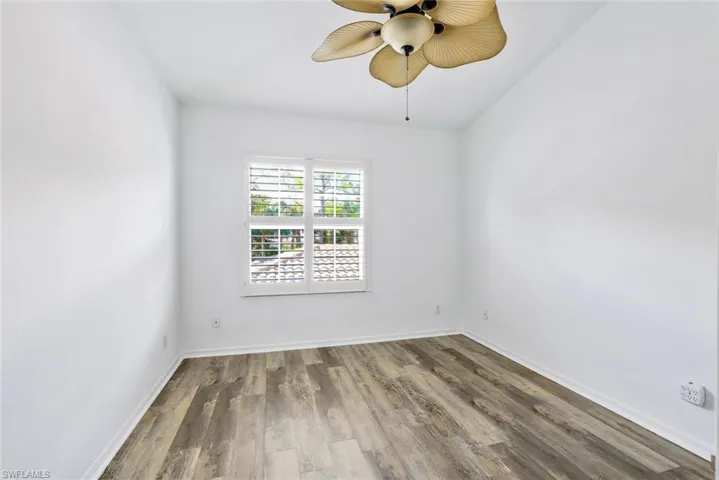 Freshly painted 2nd Bedroom is 11'0" x 11'4" with luxury vinyl flooring, plantation shutters and custom fan/light