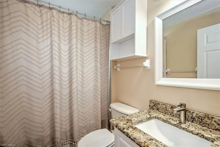 Bathroom with granite and tub/shower combintaion.