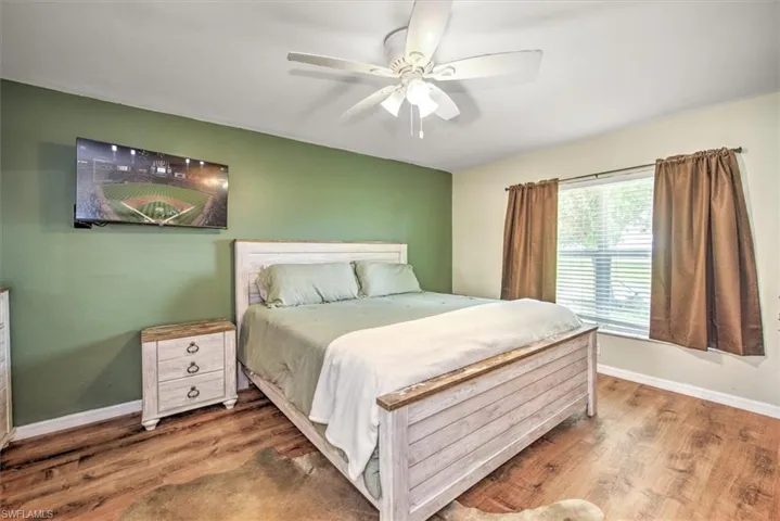 Bedroom with ceiling fan and vinyl plank, security system, his & hers closets