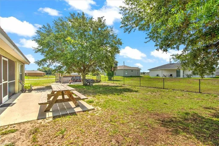 View of yard with open patio, screened porch and fenced yard