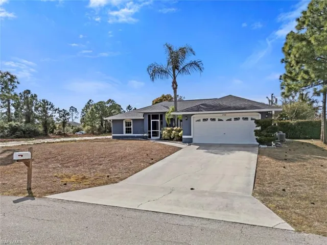 Ranch-style home featuring driveway, an attached garage, stucco siding, and a shingled roof