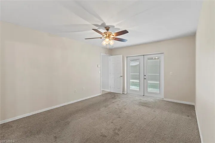 Carpeted MASTER room featuring french doors and ceiling fan