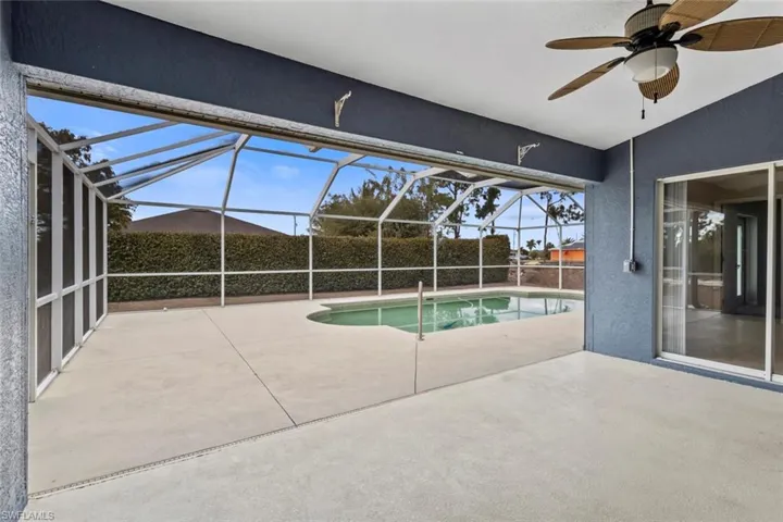 View of pool featuring patio surround, a sunroom, and glass enclosure