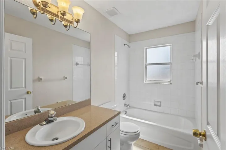 Full bathroom with shower / washtub combination, vanity, and light tile patterned floors