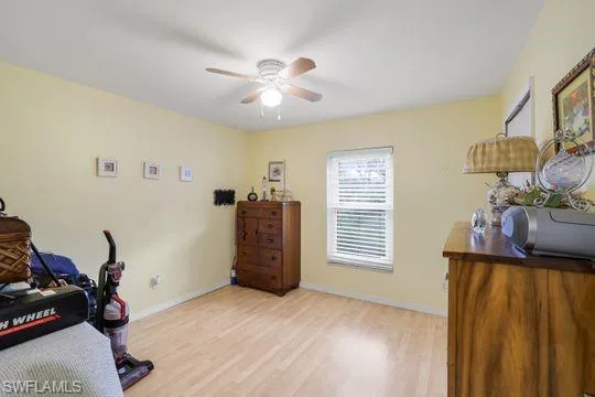 Office space with light wood-style flooring, baseboards, and a ceiling fan
