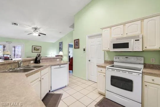 Kitchen featuring white appliances, visible vents, light countertops, a sink, and light tile patterned flooring