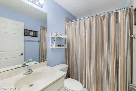 Full bath featuring a shower with curtain, vanity, and toilet