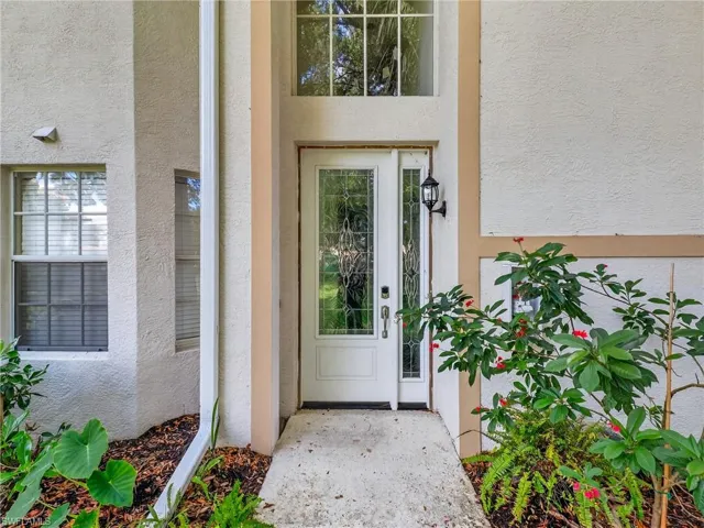 Doorway to property featuring stucco siding
