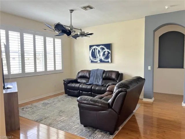 Living room with light wood finished floors and arched walkways