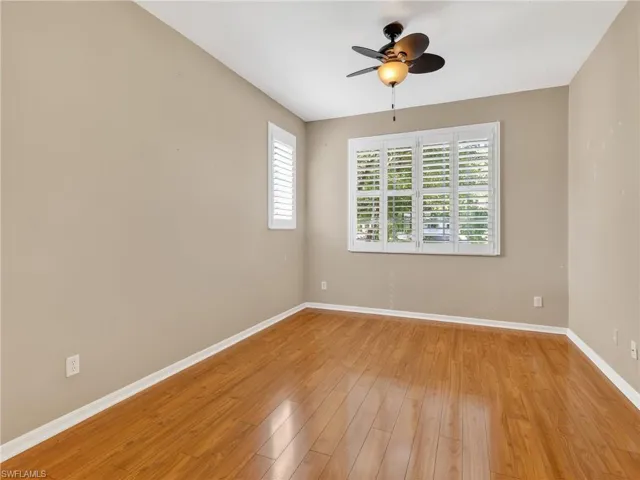Empty room with light wood-style floors and a ceiling fan