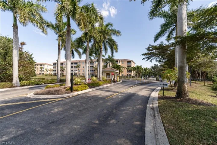 View of road featuring traffic signs, a gated entry, and curbs