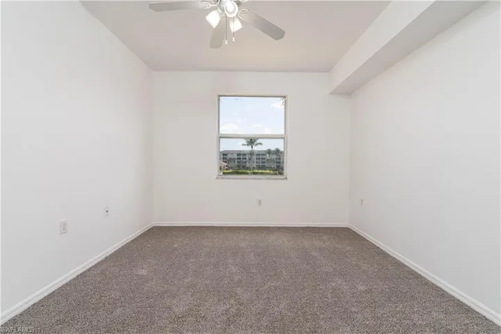 Empty room featuring carpet, a ceiling fan, and baseboards