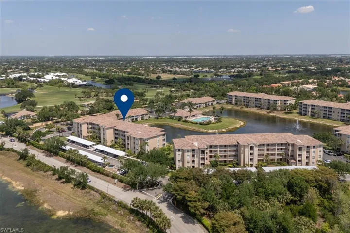 Birds eye view of property with view of golf course and a water view