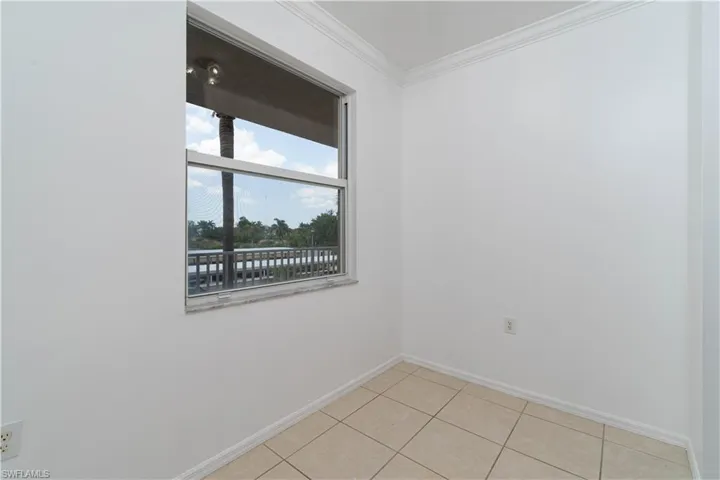 Unfurnished room featuring baseboards, ornamental molding, and light tile patterned flooring