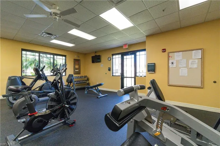 Gym featuring a ceiling fan, visible vents, and a paneled ceiling