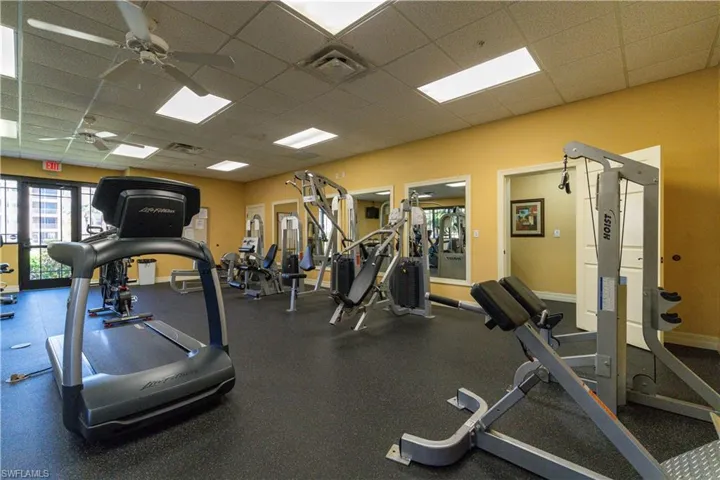 Exercise room featuring a paneled ceiling, visible vents, and a ceiling fan