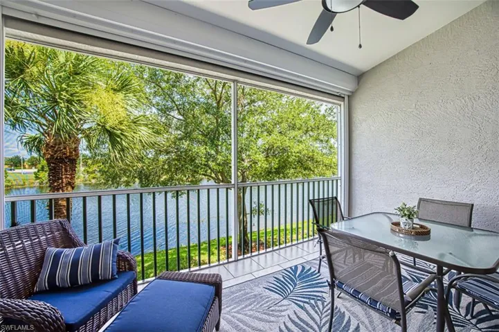 Sunroom featuring vaulted ceiling, a water view, and ceiling fan