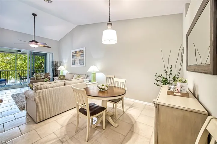 Tiled dining room featuring ceiling fan and vaulted ceiling