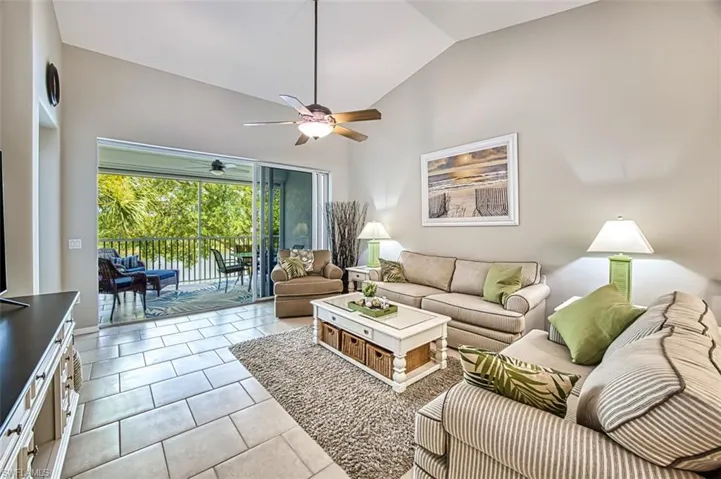 Living room featuring tile floors, high vaulted ceiling, and ceiling fan