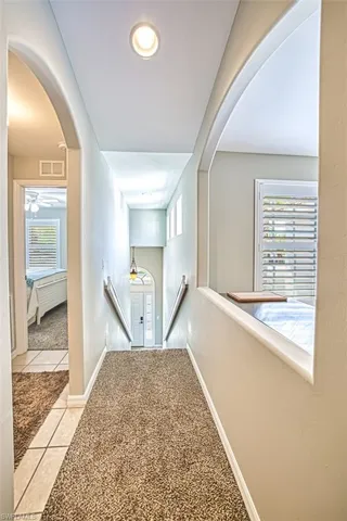 Hall featuring a healthy amount of sunlight and light tile flooring