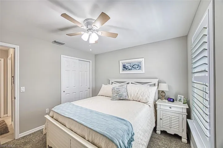 Carpeted bedroom with a closet and ceiling fan