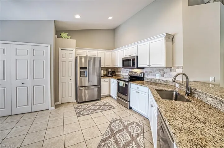 Kitchen featuring white cabinets, appliances with stainless steel finishes, sink, and tasteful backsplash