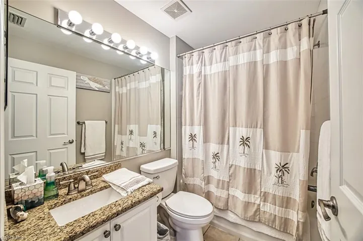 Bathroom featuring toilet, tile floors, and large vanity