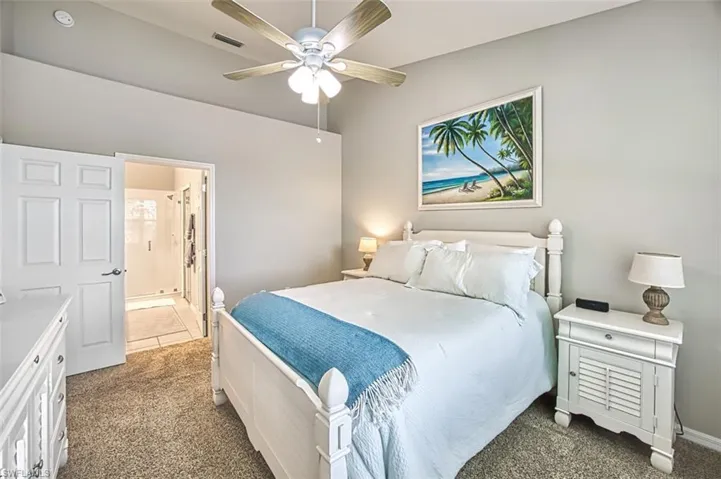 Tiled bedroom featuring ensuite bathroom and ceiling fan