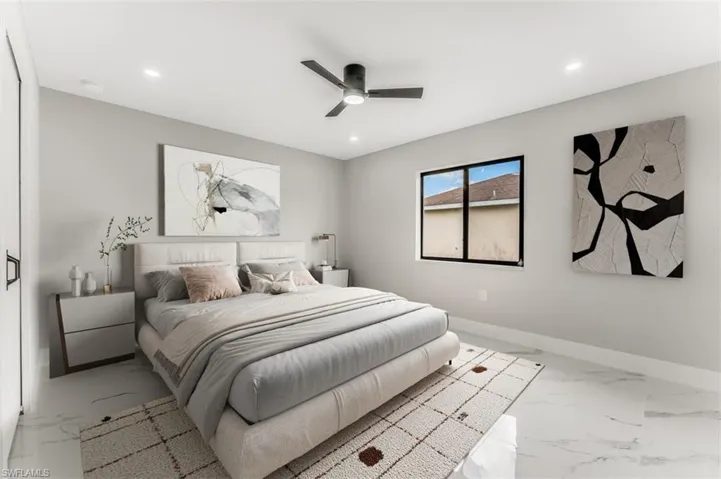 Bedroom staged with recessed lighting, marble finish flooring, and a ceiling fan