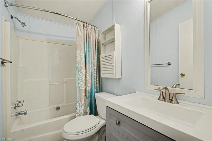 Bathroom with vanity and shower / bath combo with shower curtain