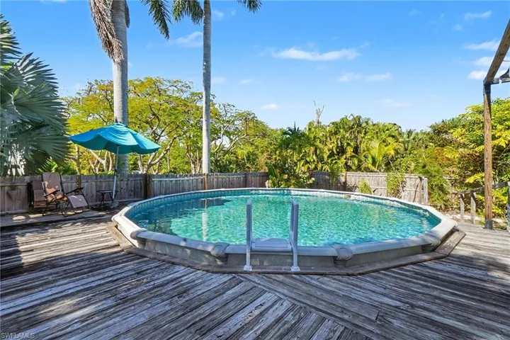 View of pool with a deck and a fenced backyard