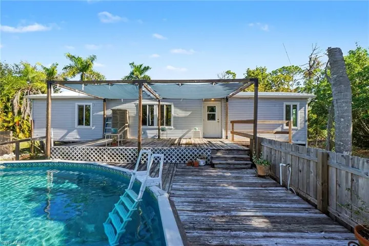 Front entry of the property featuring a wooden deck and pool.