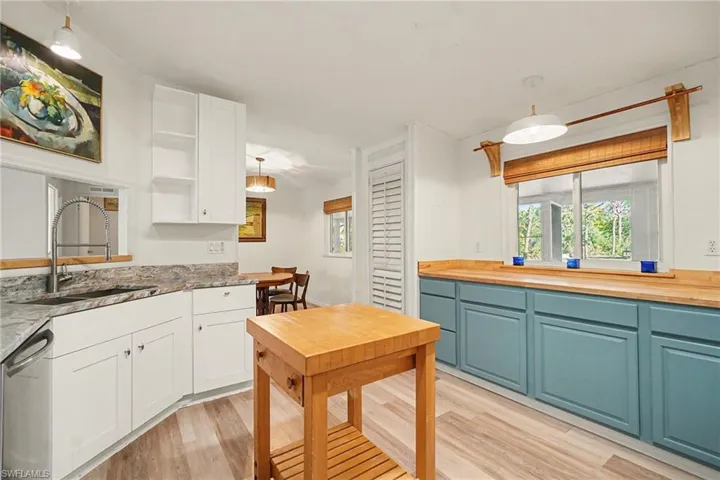 Kitchen with hanging light fixtures, light wood-type flooring, and wooden counters