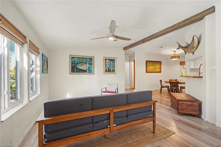 Living room with wood finished floors, lofted ceiling, and a ceiling fan