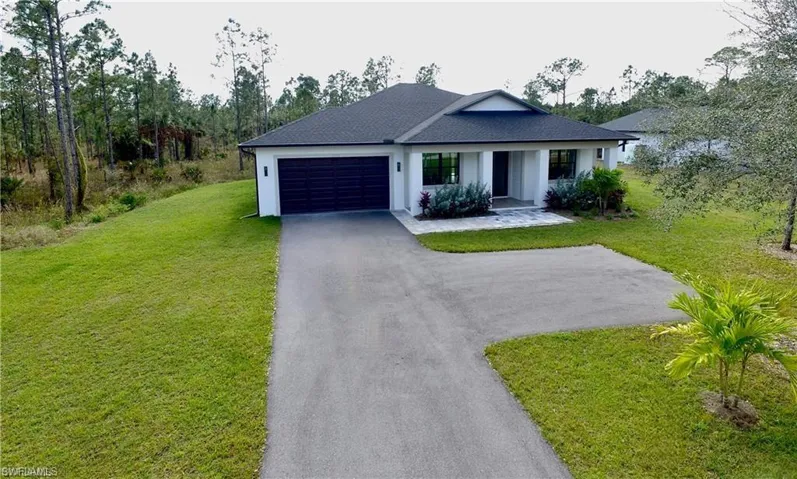 Ranch-style house with a front yard and a garage