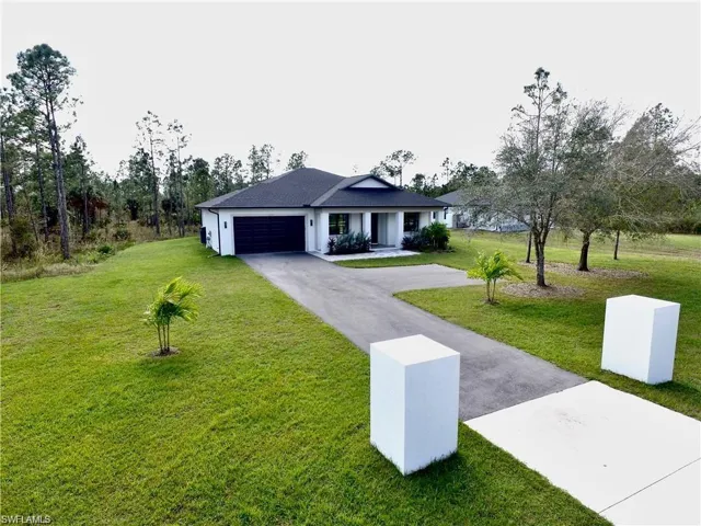 Single story home with a garage and a front lawn