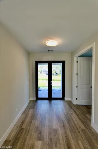 Spare room featuring french doors and wood-type flooring