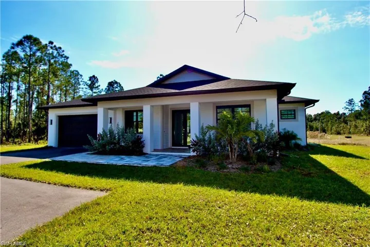 View of front of property featuring a front lawn and a garage