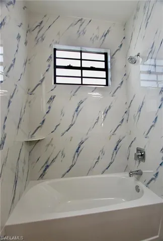 Bathroom with shower / washtub combination
