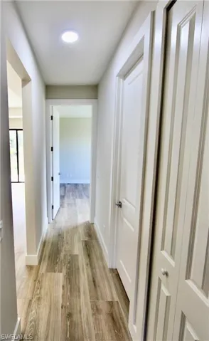 Hallway with light hardwood / wood-style flooring