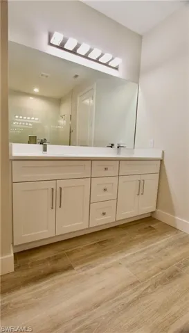 Bathroom featuring vanity, a shower, and hardwood / wood-style floors